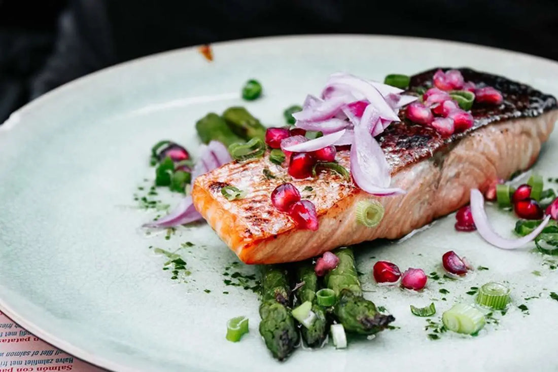 Grilled salmon filet with garnish on a plate. 