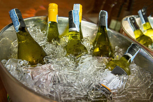 Bottles of white wine in an ice bucket.