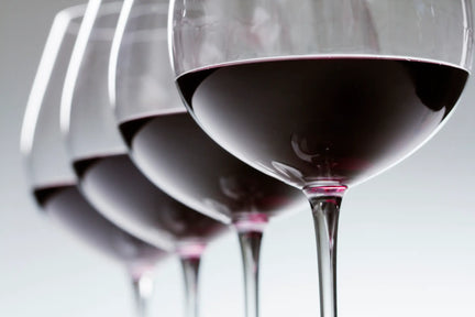 Close-up on four glasses of red wine.
