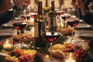 Wine glasses with red wine, cheese platter, and candles on a festive table.