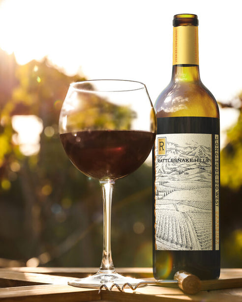 Longitude 120 West 2018 Cabernet Sauvignon Rattlesnake Hills, Washington next to a poured glass in a vineyard